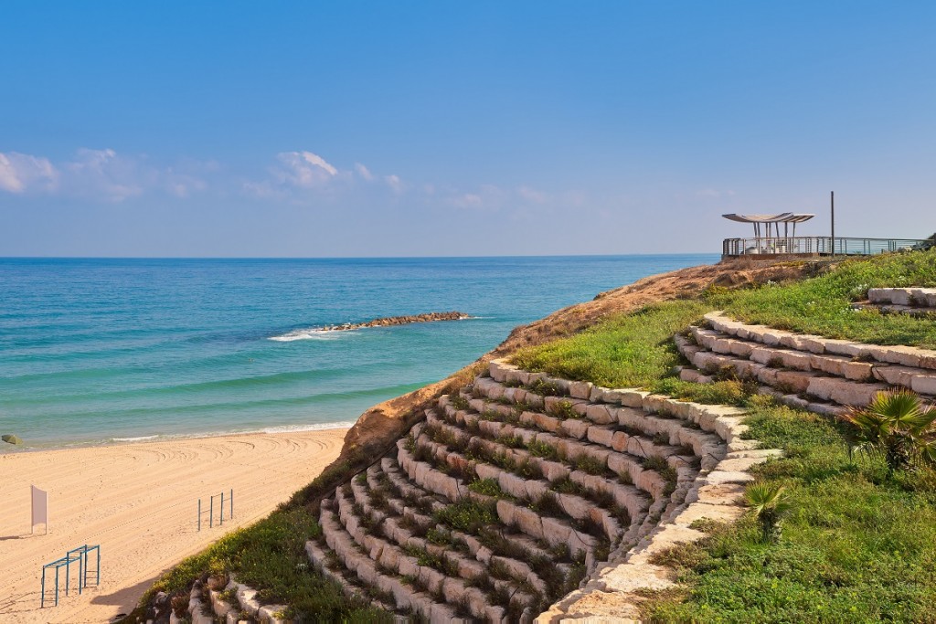 Artificial stone terrace with green grass and sand beach on Mediterranean sea in Ashkelon, Israel.