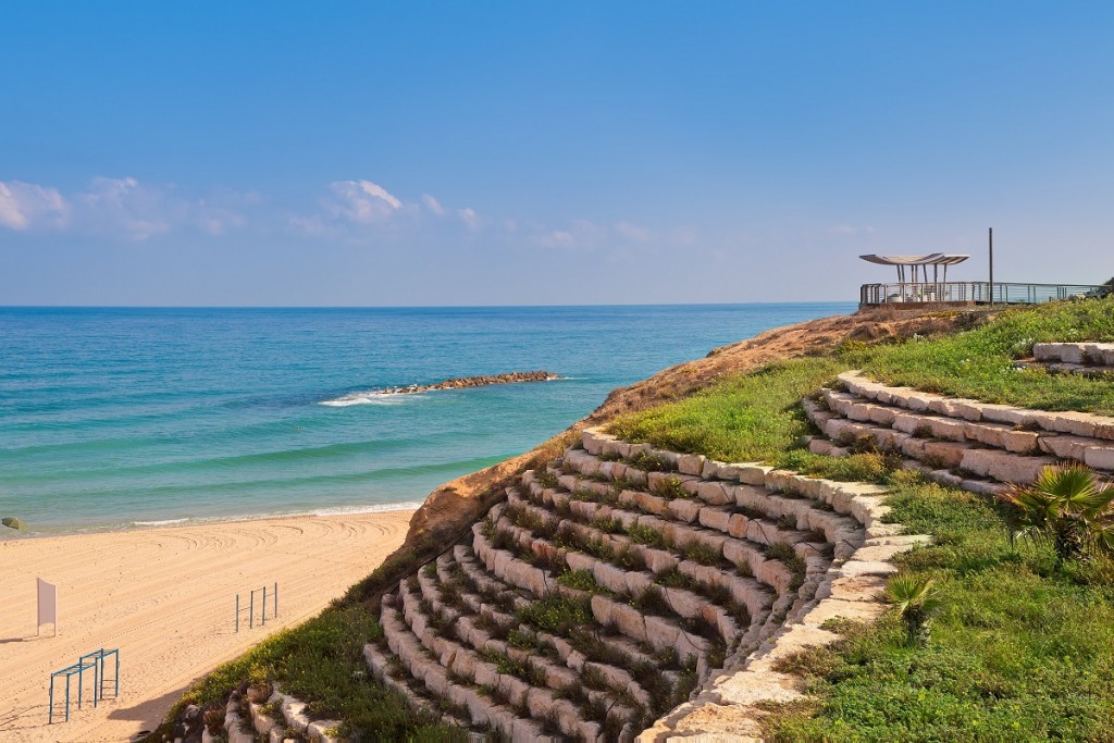 Artificial stone terrace with green grass and sand beach on Mediterranean sea in Ashkelon, Israel.