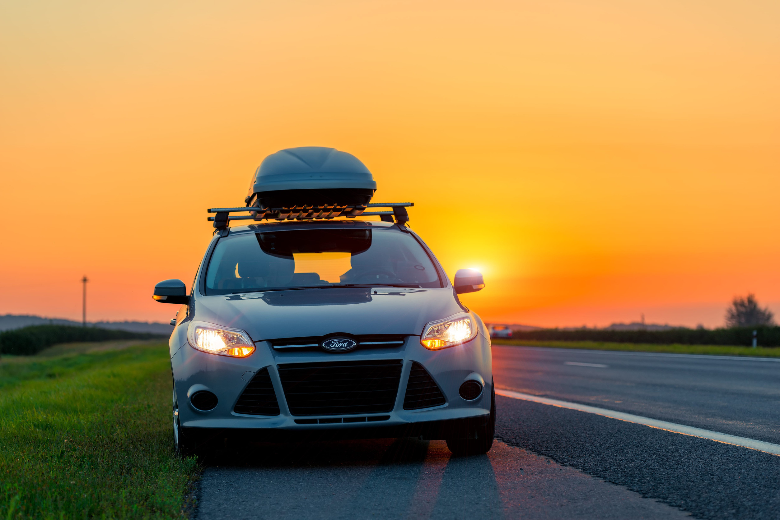 Auto s lacným strešným boxom počas jazdy vysokou rýchlosťou po diaľnici.